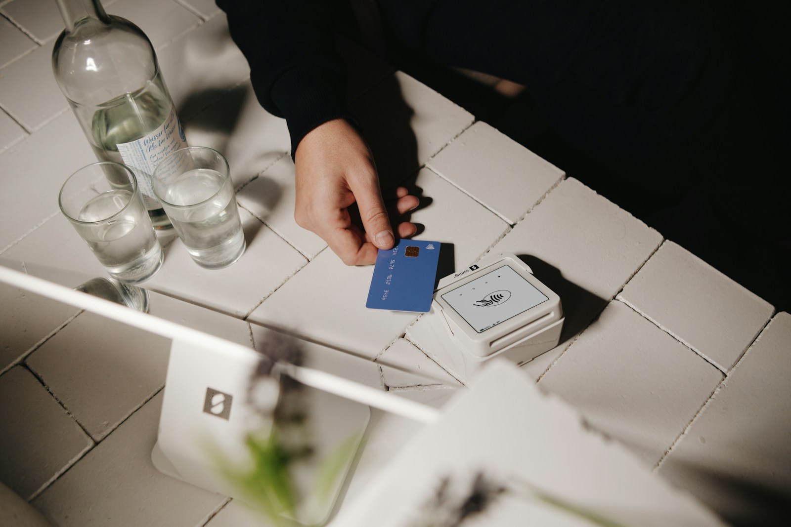 A hand is holding a blue card.